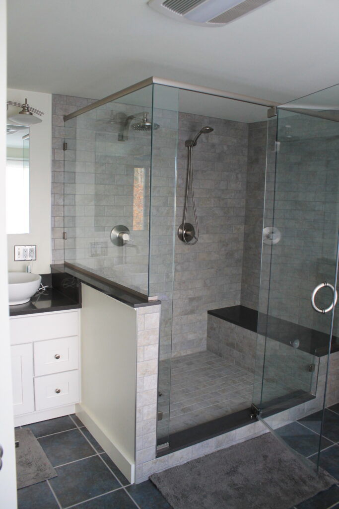 custom tile shower with rainhead and handheld fixtures for two people
